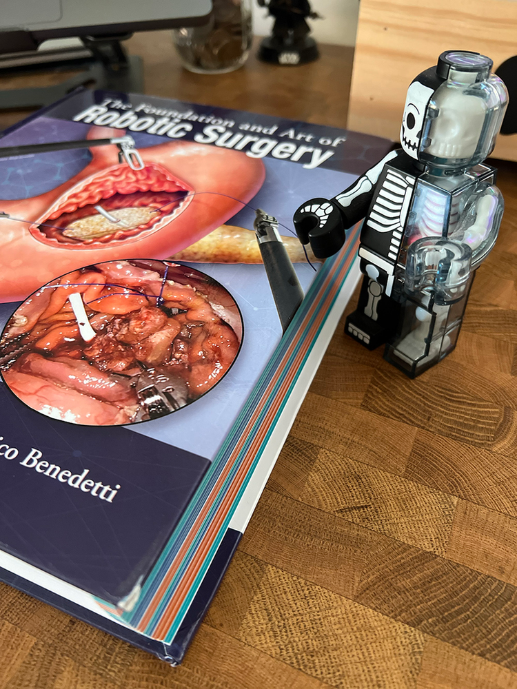 Lego with anatomy next to robotic surgery textbook