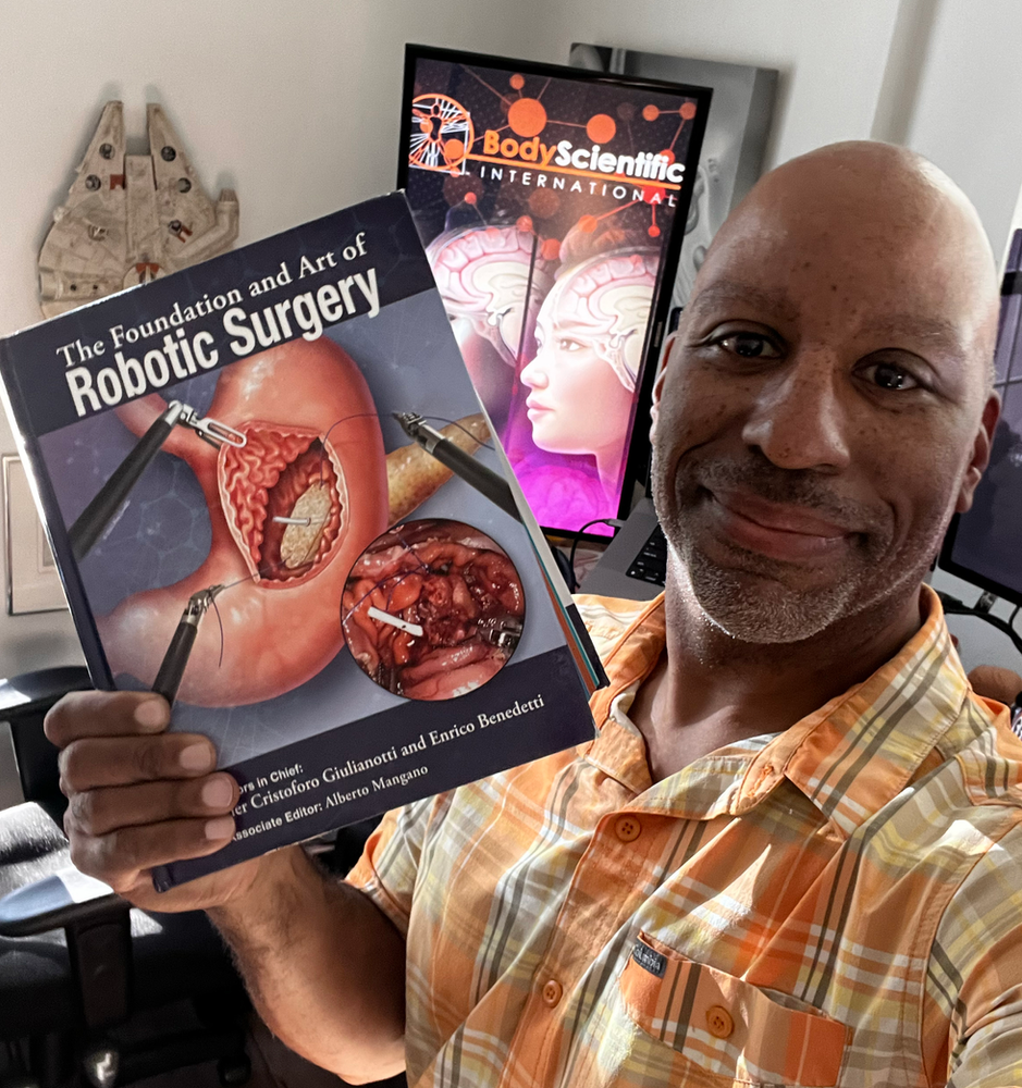 Marcelo Oliver holding the text book of robotic surgery